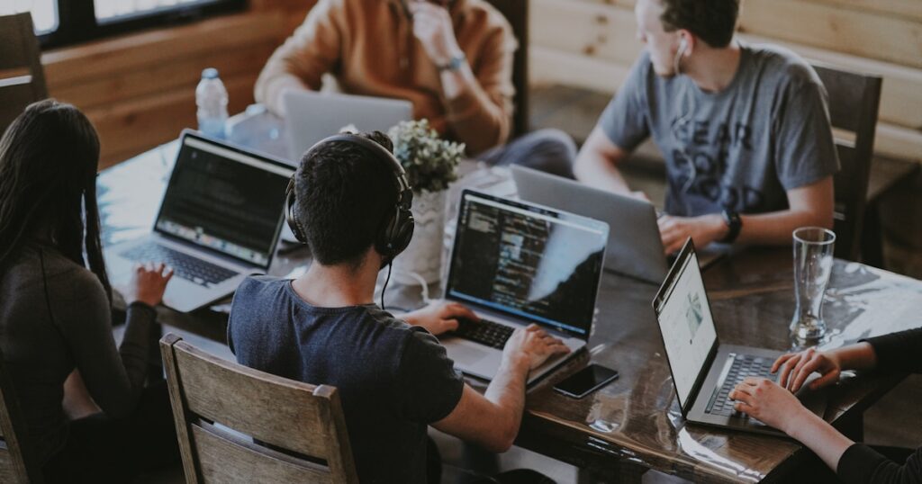A remote software development team working together on laptops, collaborating across locations