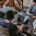 A remote software development team working together on laptops, collaborating across locations